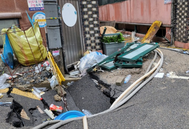 지난 8일 오후 9시 7분께 서울 관악구 부근 한 빌라 반지하에 폭우로 침수된 일가족 3명이 갇혀 신고했지만 결국 사망했다. 주민들에 따르면 사고가 난 빌라 바로 앞 싱크홀이 발생해 물이 급격하게 흘러들었고, 일가족이 고립돼 구조되지 못했다. 사진은 사고 현장. 연합뉴스