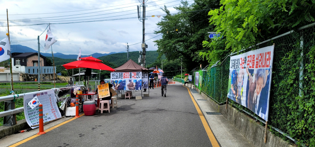 문 전 대통령을 반대하는 단체와 개인, 1인 시위자가 9일 오전 확성기를 통해 국민교육헌장과 애국가를 내보낸 뒤 경찰과 합의한 대로 시위를 하지 않고 있다. 김태권 기자