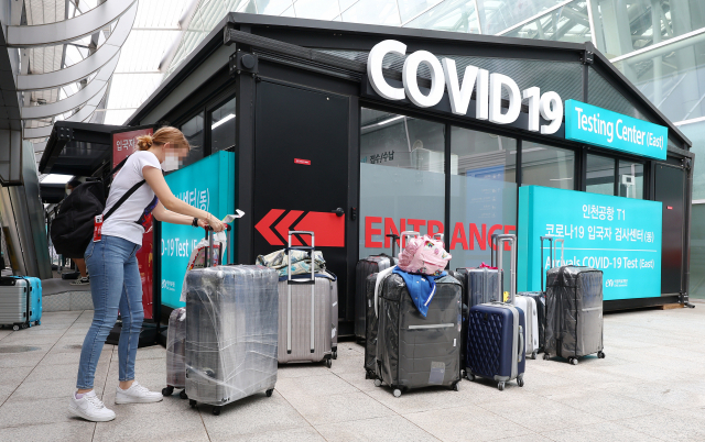 단기체류 외국인들에 대한 입국 1일차 유전자증폭(PCR) 검사가 시행된 10일 오후 인천국제공항 제1여객터미널 코로나19 검사센터 앞에서 검사를 마친 입국자가 짐을 찾고 있다. 이날부터 다음 달 9일까지 인천·김해·제주 공항으로 입국하는 단기체류 외국인들은 공항검사센터 또는 숙소 인근 의료기관에서 입국 1일차 PCR검사를 받아야한다. 연합뉴스
