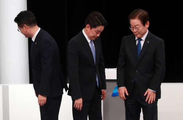 더불어민주당 박용진(왼쪽), 강훈식(가운데), 이재명 당대표 후보가 지난 9일 부산 MBC에서 열린 TV토론회에 앞서 기념촬영 후 자리로 돌아가고 있다. 연합뉴스