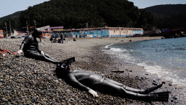 영도 감지해변에서 잠수를 연습하다 지친 취재진이 몽돌 위에서 쉬고 있는 모습. 정윤혁 PD jyh6873@busan.com