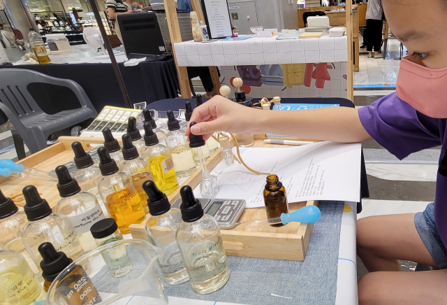 지난 4~10일 신세계백화점 김해점 1층에서는 다양한 취미 활동을 경험할 수 있는 ‘취미상점’ 팝업 스토어가 열렸다. 한 어린이가 차량용 디퓨저 만들기 체험을 하고 있다.