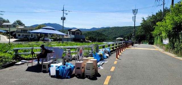 지난 22일 문 전 대통령 사저 입구 도로에서의 집회·시위 과정에서 사용됐던 시위용품이 인근에 방치돼 있다. 김태권 기자