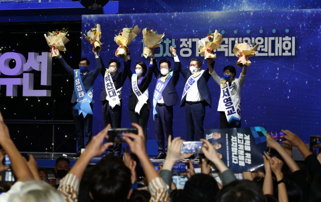 민주당 이재명 신임 당대표와 최고위원들이 28일 정기전국대의원대회에서 꽃다발을 들어보이고 있다. 김종호 기자 kimjh@