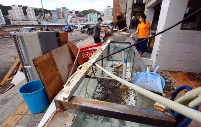 6일 오전 부산 서구 송도해수욕장 일대 상가에서 상인들이 파도에 파손당한 식당 내부 집기를 정리하고 있다. 정종회 기자 jjh@