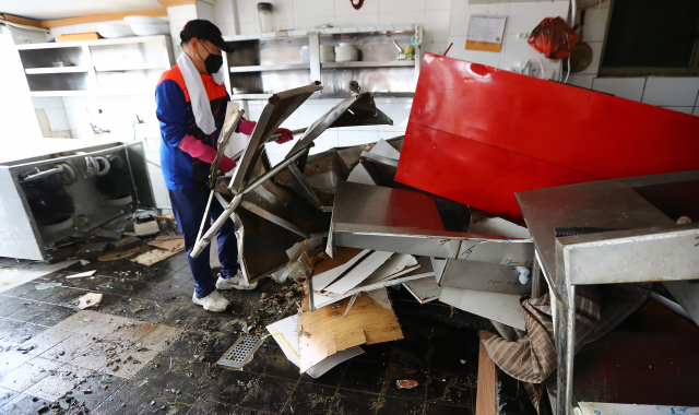 6일 오전 부산 서구 송도해수욕장 일대 상가에서 상인들이 파도에 파손당한 식당 내부 집기를 정리하고 있다. 정종회 기자 jjh@