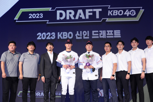 롯데 자이언츠는 15일 열린 2023 KBO 신인 드래프트에서 휘문고 내야수 김민석을 비롯한 10명을 지명했다. 롯데 성민규 단장(왼쪽 세 번째)과 스카우터들이 이날 각각 2·7라운드에 지명한 이진하(장충고)·석상호(고려대)와 기념 촬영을 하고 있다. 연합뉴스