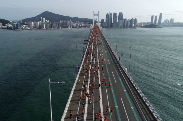 올해로 21회째를 맞는 2022 부산바다마라톤 대회가 내달 23일 광안대교 일원에서 열린다. 코로나19 여파로 지난 2년간 비대면 버추얼 레이스로 열렸던 부산바다마라톤은 3년 만에 현장 레이스로 개최된다. 지난 2019년 10월 열린 이 대회에서 마라토너들이 광안대교 위를 달리는 장면. 부산일보DB