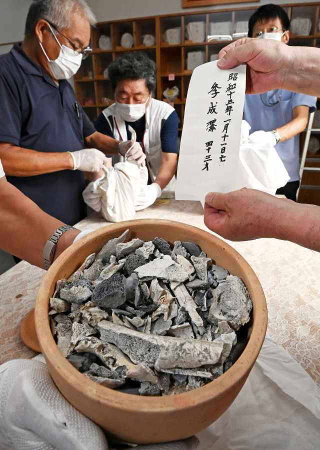 지난달 31일 일본 기타큐슈시 영생원에서 일본 시민단체 관계자들이 조선인 강제 징용 피해자들의 유골 기록을 정리하고 있다. 유골을 싼 보자기 등에는 피해자 이름과 생년월일이 표시돼 있다. 영생원에는 모두 85구의 조선인 유골이 봉안돼 있다. 서일본신문 제공