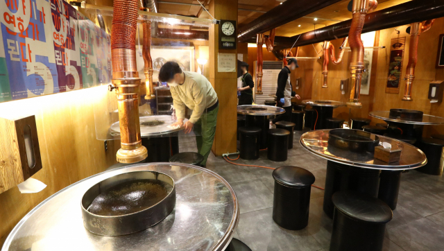 코로나19 사태의 장기화로 올해 3개 이상의 금융기관에서 대출을 받은 자영업 ‘다중채무자’가 급증했다. 이들의 상환 능력이 떨어지면 결국 경제·금융 위기로 이어질 수 있다는 경고가 나온다. 부산 시내 한 가게에서 직원이 매장 정리를 하는 모습. 부산일보DB