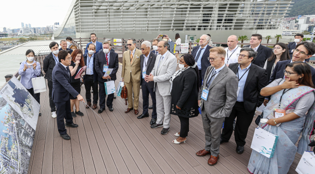주한 외교사절단이 26일 오전 부산 동구 부산국제여객터미널 하늘공원에서 2030 부산엑스포 부지를 살펴보며 북항 통합개발 사업에 관해 설명을 듣고 있다.
