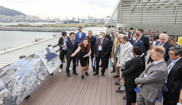 주한 외교사절단이 26일 오전 부산 동구 부산국제여객터미널 하늘공원에서 2030 부산엑스포 부지를 살펴보며 북항 통합개발 사업에 관해 설명을 듣고 있다.