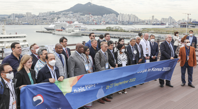 주한 외교사절단이 26일 오전 부산 동구 부산국제여객터미널 하늘공원에서 2030 부산엑스포 부지를 살펴보며 북항 통합개발 사업에 관해 설명을 듣고 기념촬영을 하고 있다.