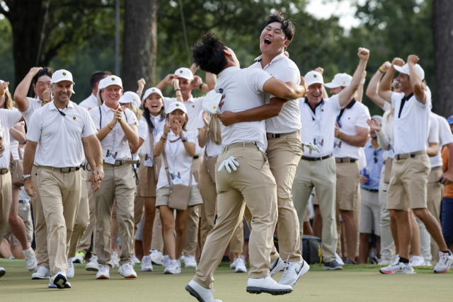 프레지던츠컵 골프 대회 포볼 매치 플레이에서 승리한 뒤 기뻐하는 인터내셔널 팀 김주형(왼쪽)과 김시우. UPI연합뉴스