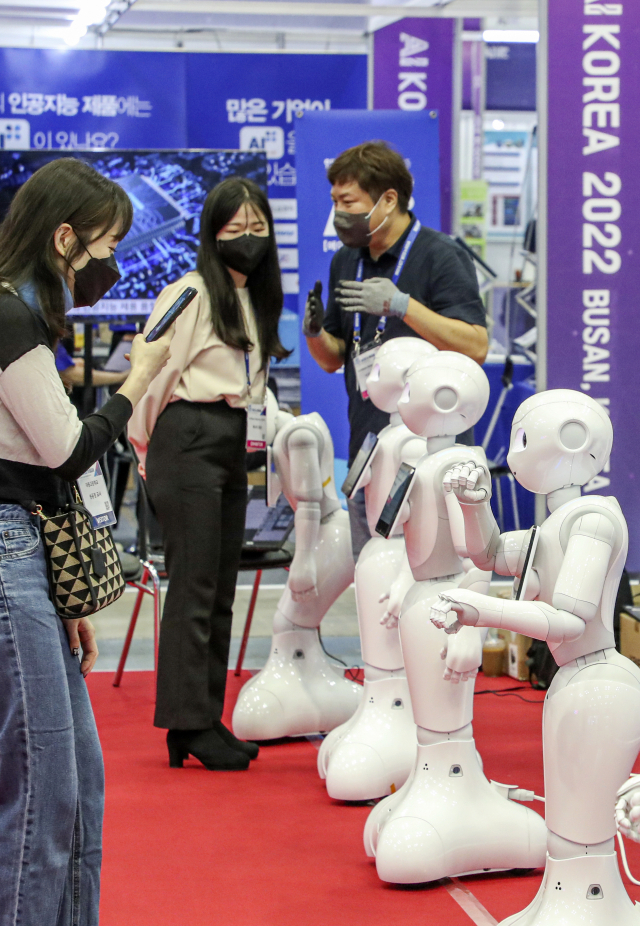'K-ICT Week in BUSAN 2022'가 개막한 28일 부산 해운대구 벡스코 제2전시장에서 관람객들이 스마트 접객용 안내로봇을 살펴보고 있다.