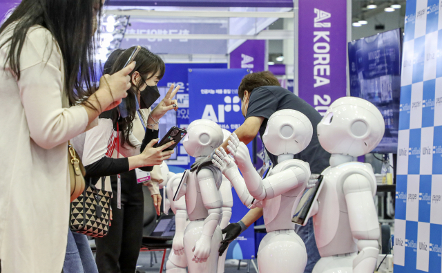 'K-ICT Week in BUSAN 2022'가 개막한 28일 부산 해운대구 벡스코 제2전시장에서 관람객들이 스마트 접객용 안내로봇을 살펴보고 있다.