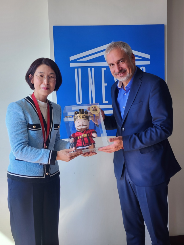 부산문화재단 이미연(왼쪽) 대표가 유네스코 에르네스토 오토네 라미레즈 사무총장보를 만나 조선통신사 정사 인형을 전달하고 있다. 부산문화재단 대표