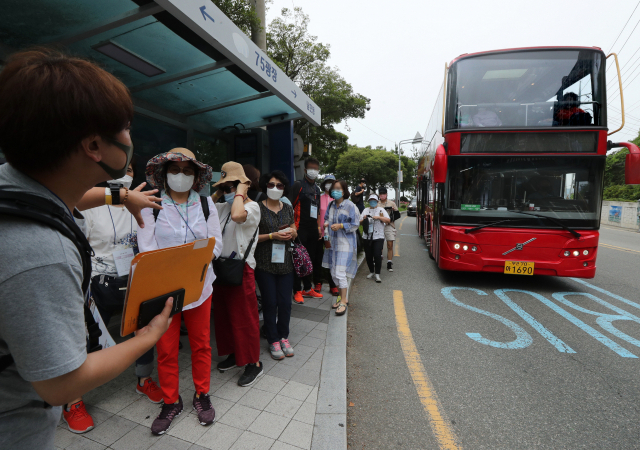 그동안 동부산 관광지 중심으로 운행돼 온 부산시티투어버스가 서부산 주요 거점을 경유하는 신규 노선을 추가, 다음 달부터 본격적인 운행에 들어갈 예정이다. 시민과 관광객들이 부산시티투어버스를 이용하기 위해 정류소에서 기다리고 있다. 부산일보DB