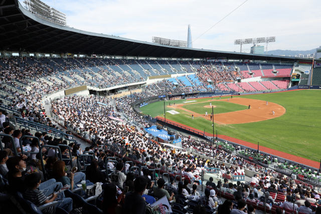 지난 25일 오후 서울 잠실야구장에서 마스크를 팔에 건 한 관중이 프로야구 경기를 관람하고 있다. 2 연합뉴스