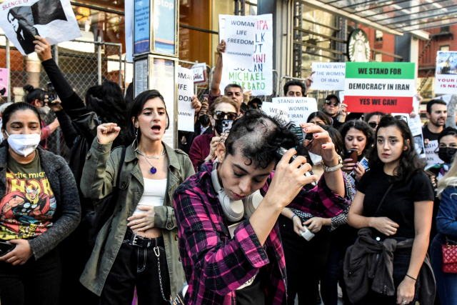 지난 27일 미국 뉴욕에서 이란 반정부 시위대의 한 여성이 마흐사 아미니(22)의 사망 사건에 항의하며 삭발하고 있다. 아미니는 히잡을 제대로 쓰지 않았다는 이유로 이란의 지도 순찰대에 체포됐다가 지난 16일 의문사했다. 로이터연합뉴스
