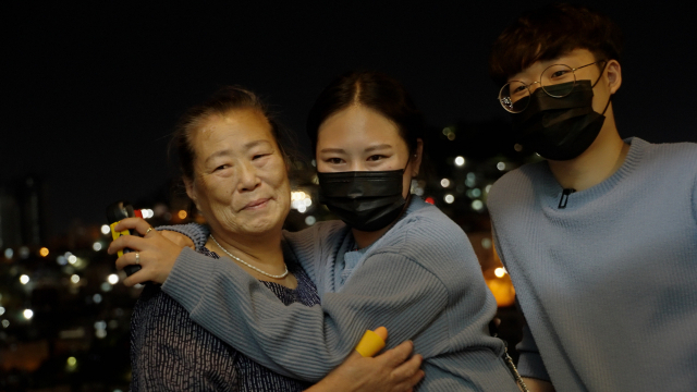 외할머니와 함께 포즈를 취한 손녀. 꼭 껴안은 손에서 사랑이 느껴집니다.