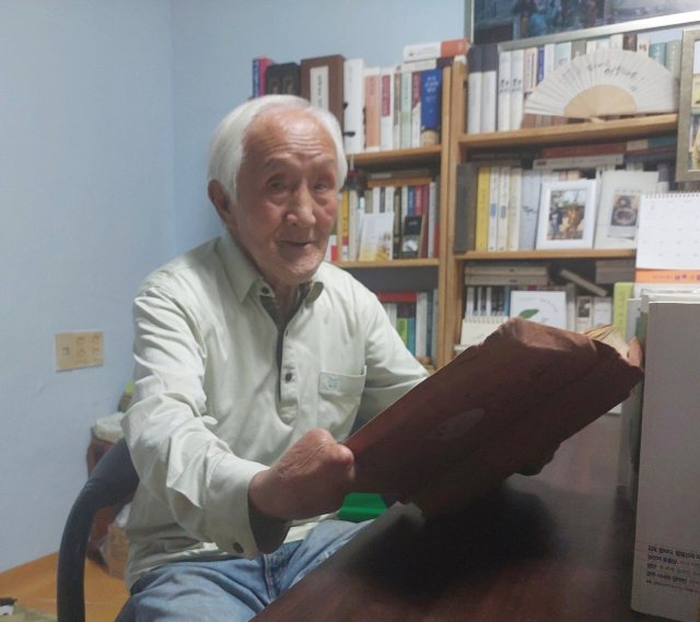 부산 사하구 감천동 '스타' 오광봉(90) 씨가 구매한 지 50년이 넘은 톨스토이의 <인생독본>을 꺼내 읽고 있다. 나웅기 기자 wonggy@