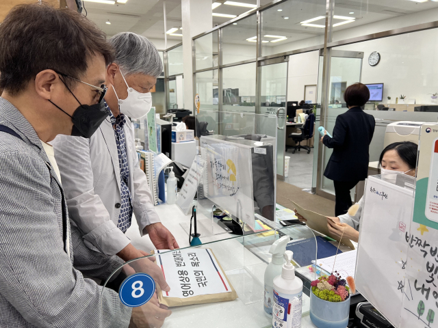 6일 오후 ‘부산영어상용정책 백지화를 위한 시민대회’가 끝난 뒤 참가자들이 시민인식조사 결과보고서와 반대서명 목록을 시청 민원실에 제출하고 있다. 한글문화연대 제공