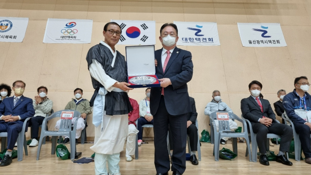 (사)대한택견회는 택견이 정식 종목으로 채택된 제10회 전국체육대회가 열린 울산에서 8일 고 민립 김상훈 전 부산일보 사장에게 감사패를 전달했다. 감사패는 김 전 사장의 아들인 김원(오른쪽) (사)살기좋은부산만들기위원회 상임대표가 대신 받았다