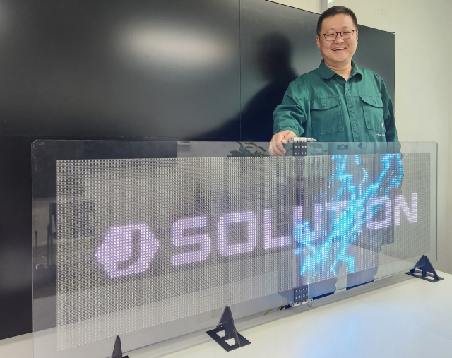 장홍석 (주)제이솔루션 대표가 부산 동구 초량동 본사에서 자사가 개발한 투명 LED 앞에서 환하게 웃고 있다.