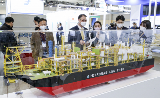 12일 부산 해운대구 벡스코 제1전시장에서 열린 '2022 국제그린해양플랜트 전시회'에 관람객들이 대우조선해양 부스에 전시된 부유식 액화천연가스설비(FLNG) 모형을 살펴보고 있다. 국내 대형조선사 3곳과 주요 기자재 및 설비 업체 등 11개국 153개사가 참가한 이번 행사는 14일까지 사흘 동안 열린다. 김종진 기자 kjj1761@