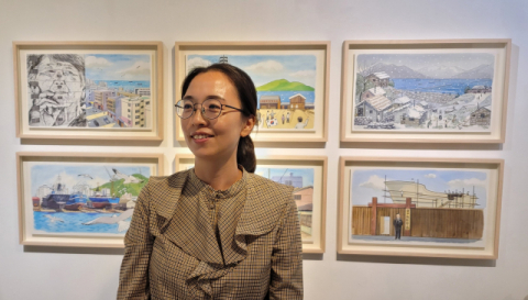 김민정 작가가 그림책 <망치질하는 어머니들> 원화 전시장에서 사라지는 도시 풍경을 기록하는 작업에 대해 이야기하고 있다. 오금아 기자