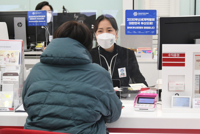 부산 대표 금융사인 BNK부산은행이 2030부산엑스포 유치에 힘을 보태기 위해 엑스포 관련 적금 상품을 출시하고 각 영업점에서 엑스포를 홍보한다. 부산은행은 최근 출시한 ‘2030부산월드엑스포적금’(위). 부산은행 영업점 창구에서 이뤄지고 있는 부산엑스포 홍보 활동. 부산은행 제공