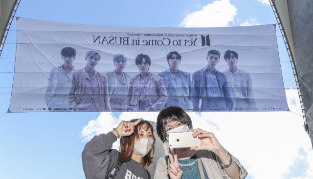 2030 부산세계박람회 유치 기원 BTS콘서트를 이틀 앞둔 13일 부산 연제구 부산아시아드주경기장을 찾은 일본인 '아미'들이 대형 현수막을 배경으로 기념사진을 찍고 있다.