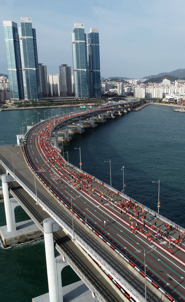 부산일보가 주최하는 성우하이텍 2022 부산바다마라톤 대회가 2019년 이후 3년 만에 23일 오전 광안대교 일원에서 열린다. 2019년 10월 부산바다마라톤 대회에 참가한 마라토너들이 광안대교 위를 달리는 모습. 부산일보DB