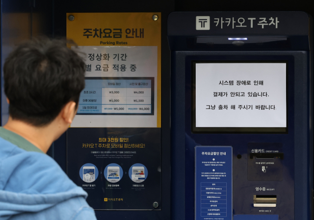 카카오톡 등에서 지난 15일 오후부터 동시다발적으로 발생한 장애가 장기화하면서 불편이 이어지는 가운데 16일 오후 경기 과천의 한 카카오T 주차장 무인정산기에 시스템 장애를 알리는 안내문이 붙어 있다. 연합뉴스