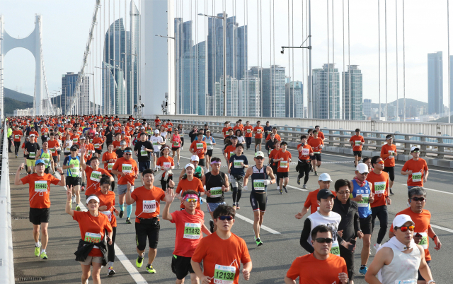 부산일보사가 주최하는 성우하이텍 2022 부산바다마라톤 대회가 23일 오전 광안대교 일원에서 열린다. 참가자들은 안전하게 마라톤을 즐기기 위해 주의사항을 숙지할 필요가 있다. 2019년 대회 때 광안대교 위를 달리는 참가자들. 부산일보DB