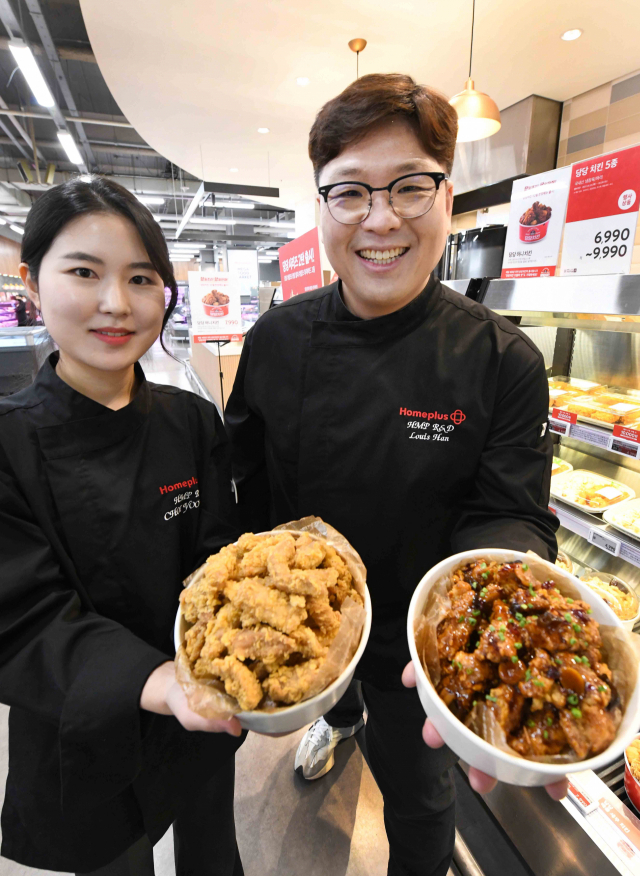 최유정(왼쪽) 홈플러스 델리사업팀 바이어 등이 ‘프라이 데이’ 행사 상품인 신메뉴 ‘당당 한돈 후라이드’와 ‘당당 한돈 갈비맛 후라이드’를 소개하고 있다. 홈플러스 제공