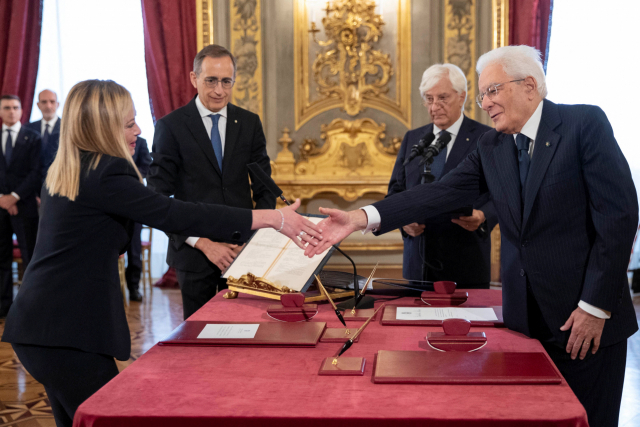 조르자 멜로니 이탈리아형제들(FdI) 대표(가운데)가 22일(현지시간) 로마의 대통령 관저인 퀴리날레 궁에서 열린 총리 취임 선서식에 참석해 세르조 마타렐라 대통령과 악수하고 있다. 연합뉴스