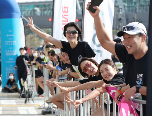 23일 열린 ‘성우하이텍 2022 부산바다마라톤 대회’에서 가족들과 대회 참가 동료들이 결승점을 통과하는 선수들을 응원하고 있다. 작은 사진은 대회 참가한 정옥숙 씨가 손녀·가족과 광안대교에 오른 모습. 정대현 기자 jhyun@