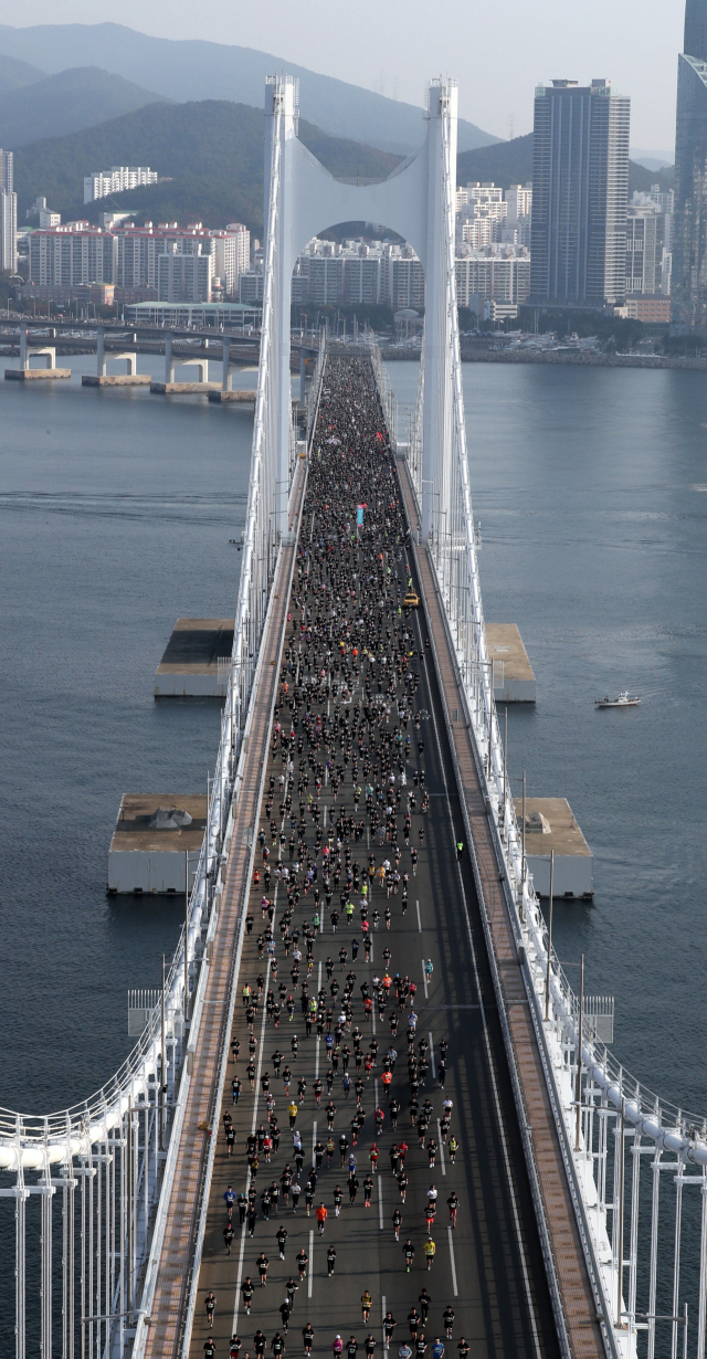 부산일보가 주최하는 ‘성우하이텍 2022 부산바다마라톤 대회’가 2019년 이후 3년 만에 23일 오전 광안대교 일원에서 열렸다. 1만 명에 이르는 마라토너들이 부산 앞바다를 가로지르며 광안대교 위를 달리고 있다. 이재찬 기자 chan@
