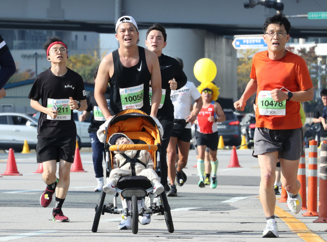아빠가 유모차를 끌며 달리는 동안 한가롭게 잠든 아이 모습이 이채롭다. 정대현 기자