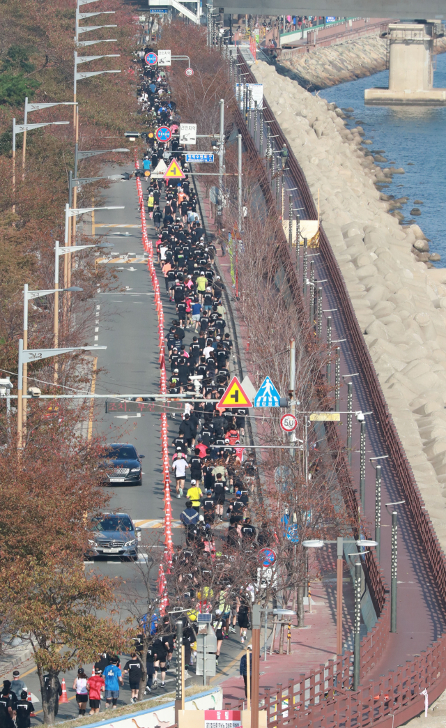 10km 코스 참가자들이 광안리해수욕장 앞 해변길을 줄지어 달리고 있다. 김경현 기자 view@