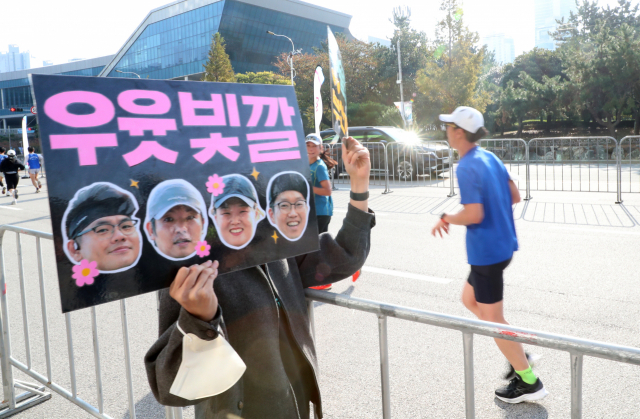 10km 결승선 앞에서 한 시민이 재미난 피켓을 들고 참가자들을 응원하고 있다. 정대현 기자