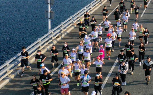 화창한 가을 날씨를 만끽하며 광안대교 위를 달리는 10km 코스 마라토너들이 드론 카메라를 향해 손짓하고 있다. 정종회 기자 jjh@
