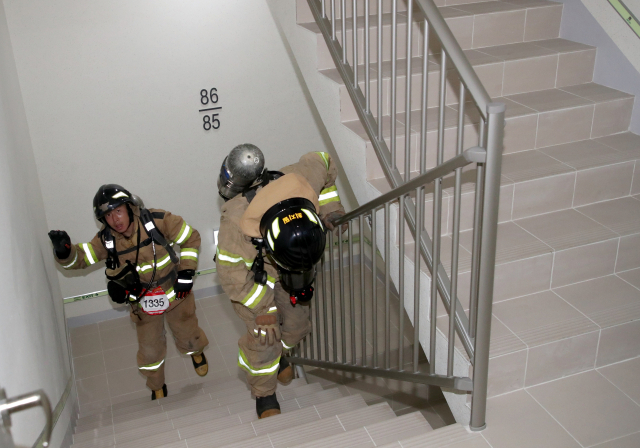 26일 오전 부산시 해운대구 101층 빌딩 LCT에서 열린 '전국소방공무원 해운대 LCT 계단오르기 대회' 참가 소방관들이 힘겹게 계단을 오르고 있다.