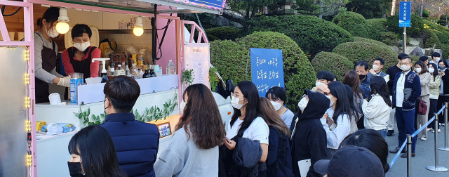 27일 부산 동의대 본관 주차장에 도착한 커피차에서 야구부 선수와 교직원, 학생들이 커피를 제공받고 있다.