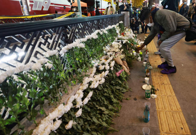 30일 오후 서울 용산구 지하철 6호선 이태원역 1번 출구 앞에 마련된 '핼러윈 인파' 압사 사고 희생자 추모 공간을 찾은 외국인이 헌화하고 있다. 연합뉴스