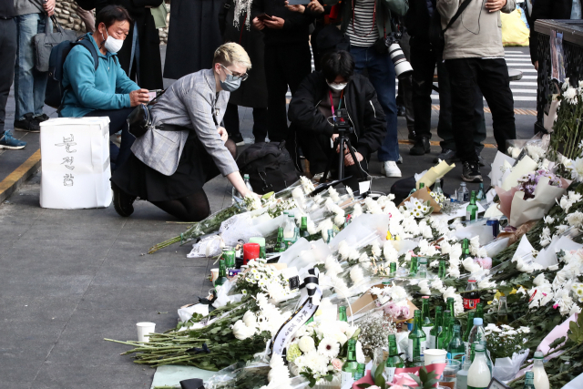 한 외국인이 지난달 31일 서울 이태원역 1번 출구 앞에 마련된 ‘이태원 참사’ 희생자 추모공간에 헌화하고 있다. 김종호 기자 kimjh@