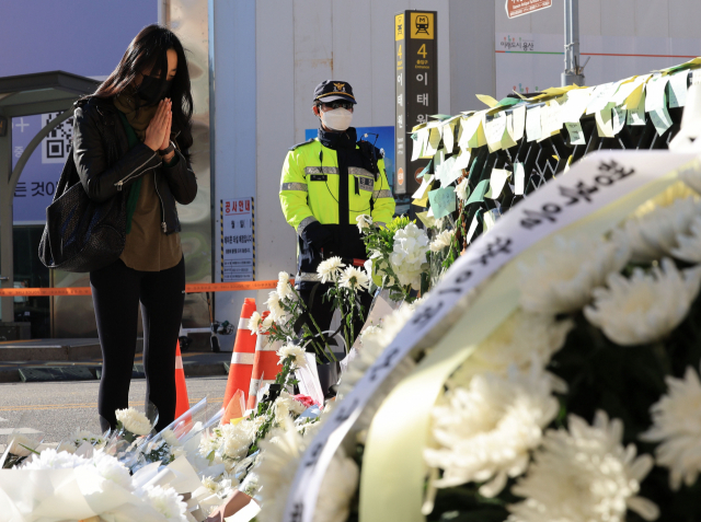 2일 서울 용산구 이태원역 1번 출구 앞 참사 추모 공간을 찾은 시민이 희생자를 추모하고 있다. 연합뉴스