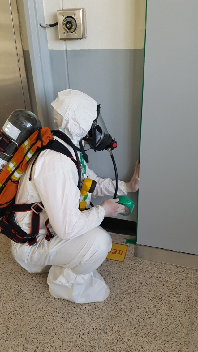 지난 4일 오전 11시 35분께 부산 사상구의 한 중학교에서 과학실험 중 액체 수은이 누출돼 학생과 교사 등 10여 명이 병원으로 옮겨졌다. 소방 관계자가 과학실을 폐쇄하고 있는 모습. 부산소방재난본부 제공